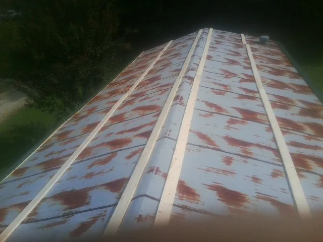 Rusted metal roof panels with new wood purlins before replacement — Storm Damage Roof Repair in Sunny Side by Roofing Brothers