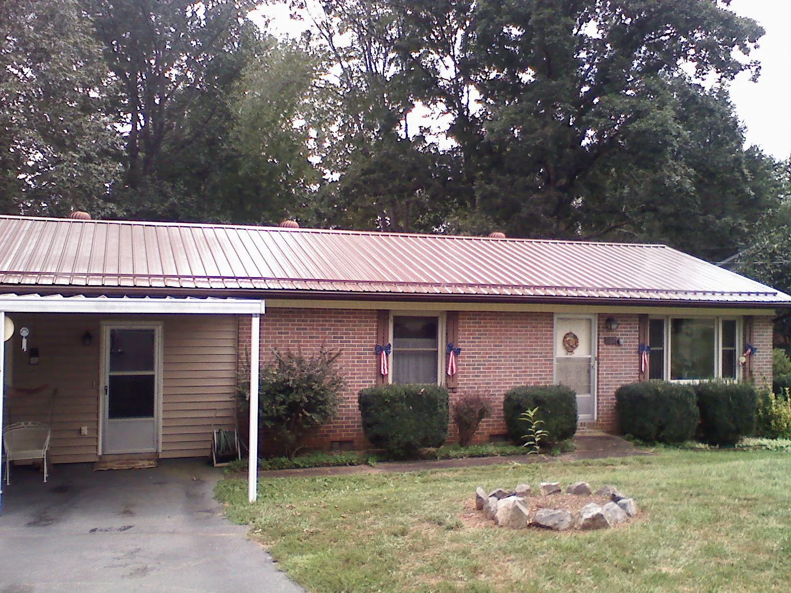 Bronze metal roof and carport on a brick ranch home — Roof Repair work by our crew in Sunny Side